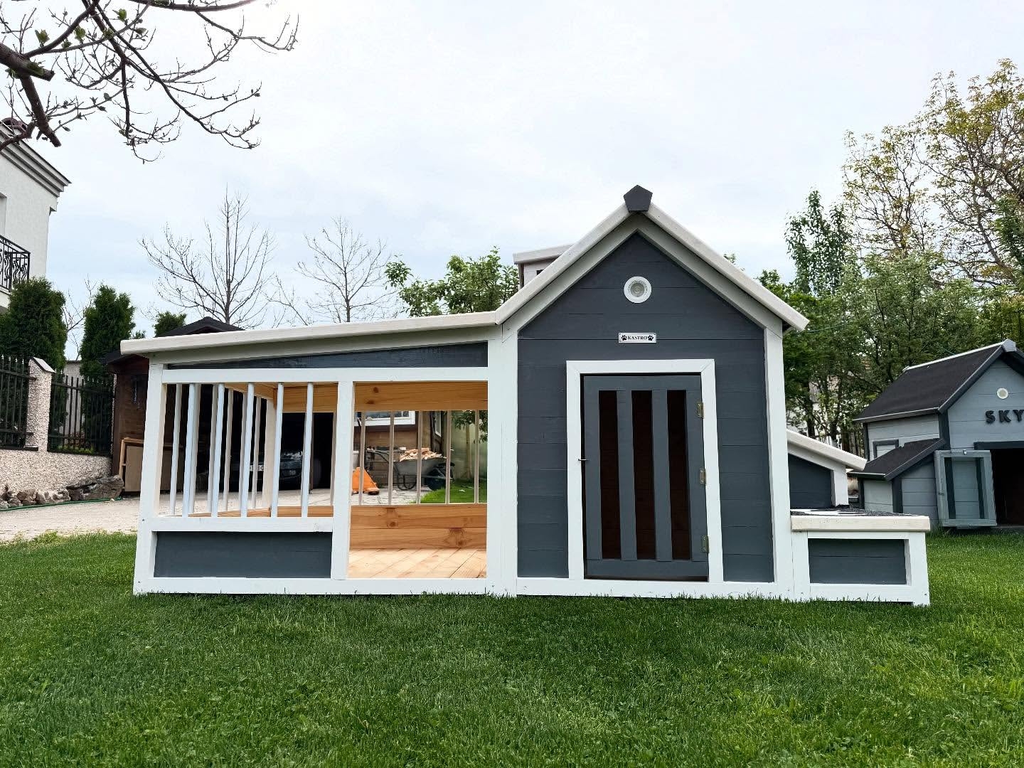 Stylish custom-built modern dog housewith white exterior and cedar accents, ideal for any backyard in the US, Canada, Australia.